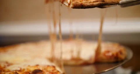 Chef lifting a slice of thin based pizza with melted cheese on a spatula Stock Footage 151502260