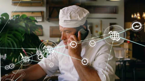 Chef lifting smartphone and typing on laptop, causing network icons multiplying Stock Footage 310665001