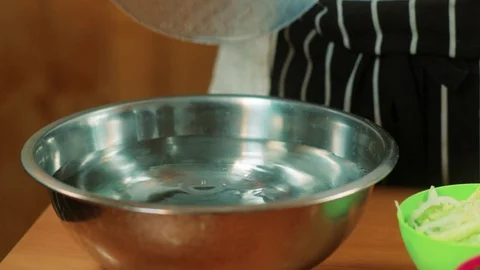 Chef lifting spring roll wrapper from bowl with water Stock Footage 83322417