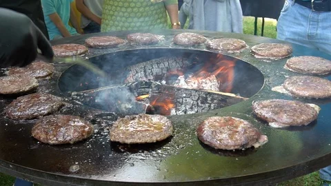Chef looking after barbecue grill fireplace with baking minced meat for burgers Stock Footage 107090081