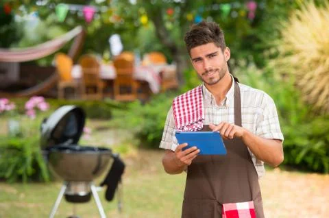 Chef looking for a recipe on tablet for a barbecue, France Foto stock