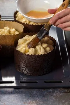 The chef lubricates the surface of the Easter cake with egg mixture Fotos de archivo