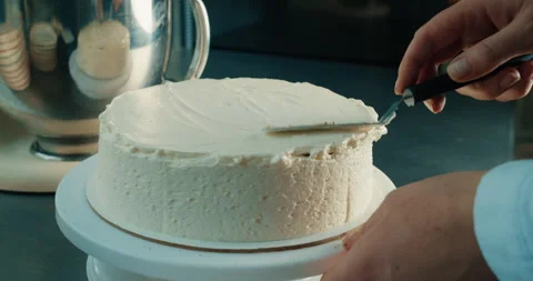 Chef makes cake buttercream decorating birthday cake on the kitchen table. Stock Footage 231629242