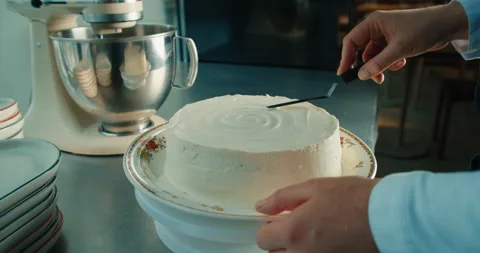 Chef makes cake buttercream decorating birthday cake on the kitchen table. Stock Footage 231629365