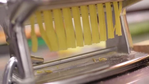 Chef makes a fresh pasta use pasta machine. Process of cutting pasta, close-up Video stock 74532247