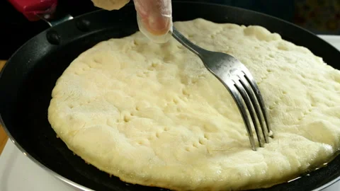 Chef makes holes with fork in fresh flatbread. Stock Footage 131439464