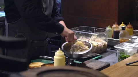 The chef makes a meat salad. He stirs the meat salad in a cup. Restaurant Stock Footage 171682382