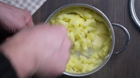 Chef makes a pot of mashed potatoes on the table in a domestic kitchen Stock Footage 296125062