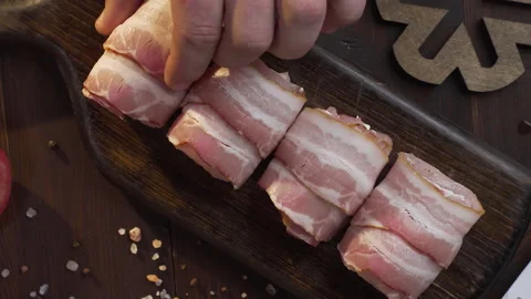 Chef makes rolls with bacon and chicken chest on the dark wooden board Video stock 143778672