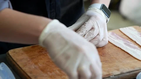 Chef makes rolls  with bacon and banana on the dark wooden board in the kitchen Stock Footage 157691087