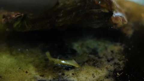 Chef makes tasty beef steak in an iron pan with onion Stockbeeldmateriaal 165482713