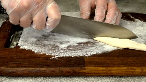 Chef makes from twisted slice dough, khvorost or faworki cookies. Vídeo Stock 132354570