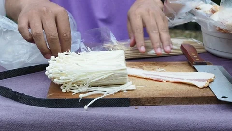The chef is making bacon wrapped in golden needle mushroom. Stock Footage 101836021