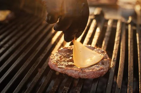 Chef making beef burger with cheese on open kitchen. Stock Photos
