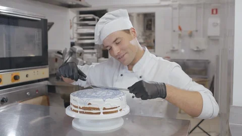 Chef making biscuit cake with white cream and blue icing liquid using cooking Stock Footage 125051856