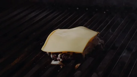 Chef making burger. Cook melts cheese on a burger. Cook uses a blow torch to Vídeo Stock 97575553