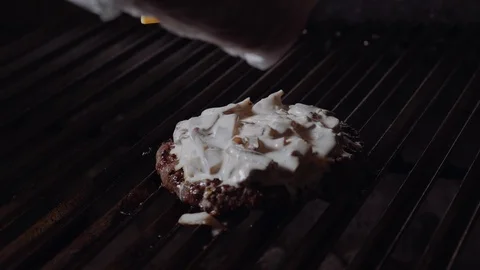 Chef making burger. Man puts cheese on the burgers and melt it on the stove. Vídeo Stock 97575468