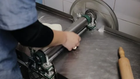 Chef making dough pastry sheeter at the kitchen. Baker forming shaping dough Stock Footage 134208575