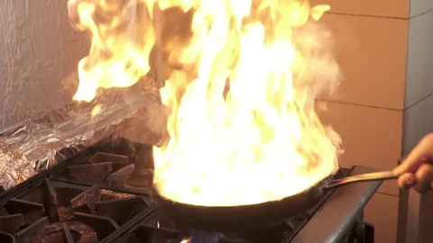 Chef making fire on the frying pan, slow motion Video stock 73514231