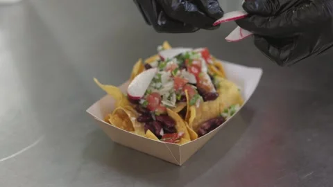 Chef making nachos adding vegetable toppings on traditional Mexican appetizer Video stock 246237428