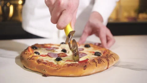 Chef Making Pizza. Cutting Pizza With a Round Knife Before Serving. Vidéo 169879002