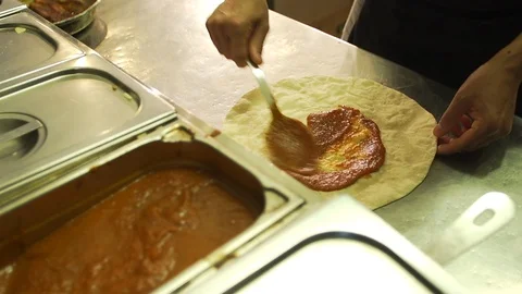 Chef making pizza in a restaurant kitchen adds sauce and cheese. Stock Footage 101646713