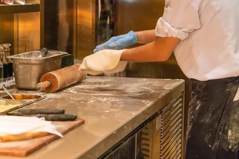 Chef making pizza in restaurant kitchen Stock Photos