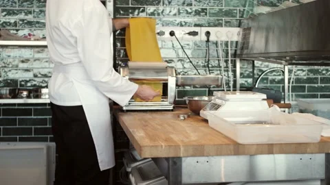 Chef making spaghetti noodles and lasagne dough with pasta machine on kitchen Stock Footage 142378166