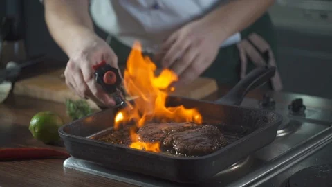 Chef making steak fillet mignon in flambe style on a grill pan. Delicious dish. Stock Footage