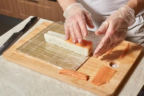 Chef making sushi. Preparing rolls with salmon Stock Photos