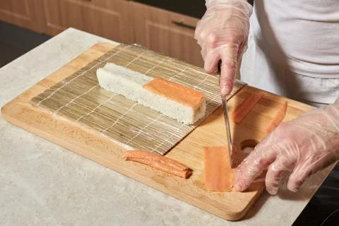 Chef making sushi. Preparing rolls with salmon Stock Photos