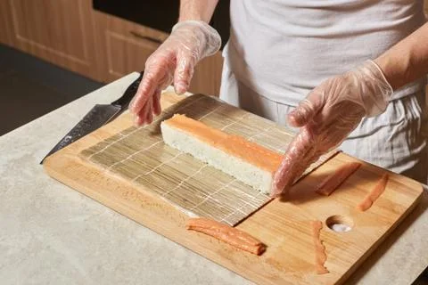 Chef making sushi. Preparing rolls with salmon Stock Photos