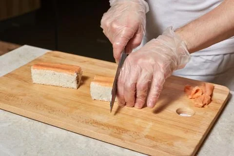 Chef making sushi. Preparing rolls with salmon Stock Photos