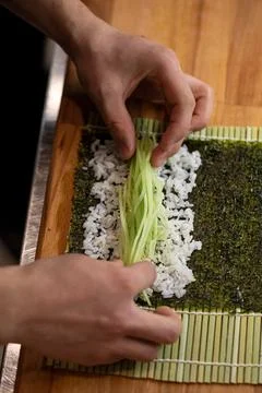 Chef making sushi roll with cucumber Stock Photos