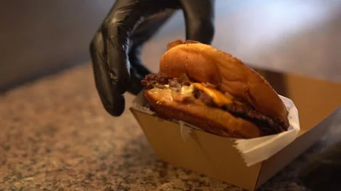 Chef making tasty burger. Cheeseburger with beef patty, cheese, tomato, onion. Stock Footage 262449649
