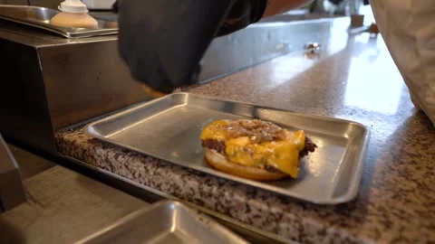 Chef making tasty burger. Cheeseburger with beef patty, cheese, tomato, onion. Stock Footage 262450762