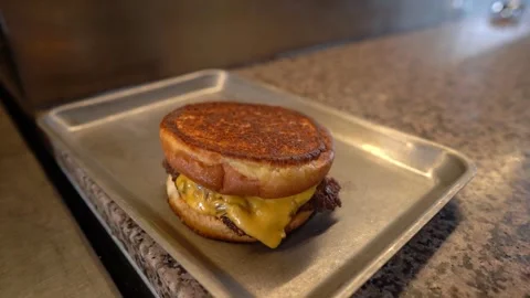Chef making tasty burger. Cheeseburger with beef patty, cheese, tomato, onion. Stock Footage 262552464