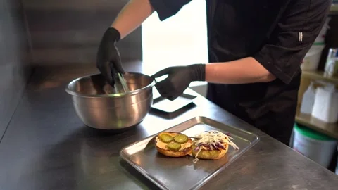 Chef making tasty burger. Cheeseburger with beef patty, cheese, tomato, onion. Stock Footage 262559584