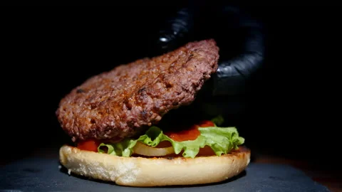 Chef making tasty burger on serving plate on black background Vídeos de archivo 168555407