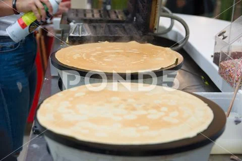 Chef making a Traditional French crepe. with maple syrup and candy Stock Photos