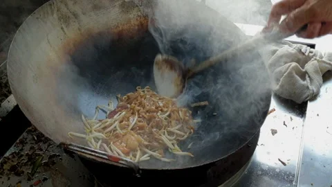 Chef is makings stir-fried rice noodle which is known as Char Koay Teow Stock Footage 156903893