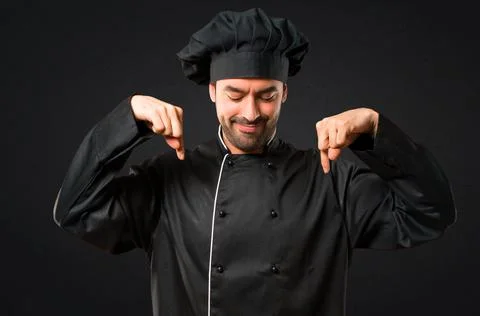 Chef man In black uniform pointing down with fingers 스톡 사진