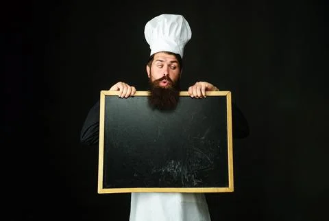 Chef man. Cook in chef hat with blank chalkboard for business lunch menu. S.. Stock Photos