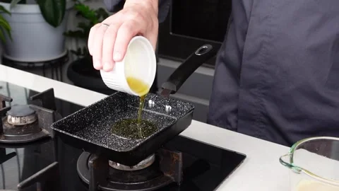 Chef man hands cooking Omelette, pouring oil and sauce into pan Stock Footage 260234514