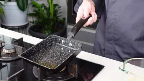 Chef man hands cooking Omelette, pouring oil and sauce into pan Stock Footage 260234557