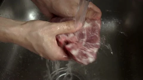Chef man hands wash red meat steak in the sink for grill stuttering Stock Footage 234961601