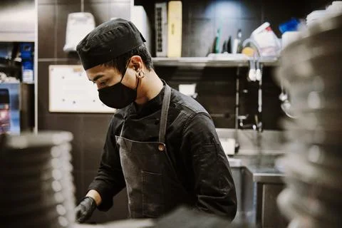 Chef man working at kitchen. Stock Photos
