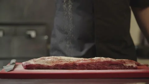 The chef marinates a raw juicy piece of ribs on a cutting board. Stock Footage 234178947