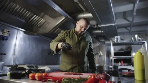 The chef marinates the steak in the kitchen, adding garlic. Slow-motion Stock Footage 232372881