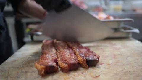 Chef masterfully slicing fried pork belly with a cleaver 스톡 동영상 323353759